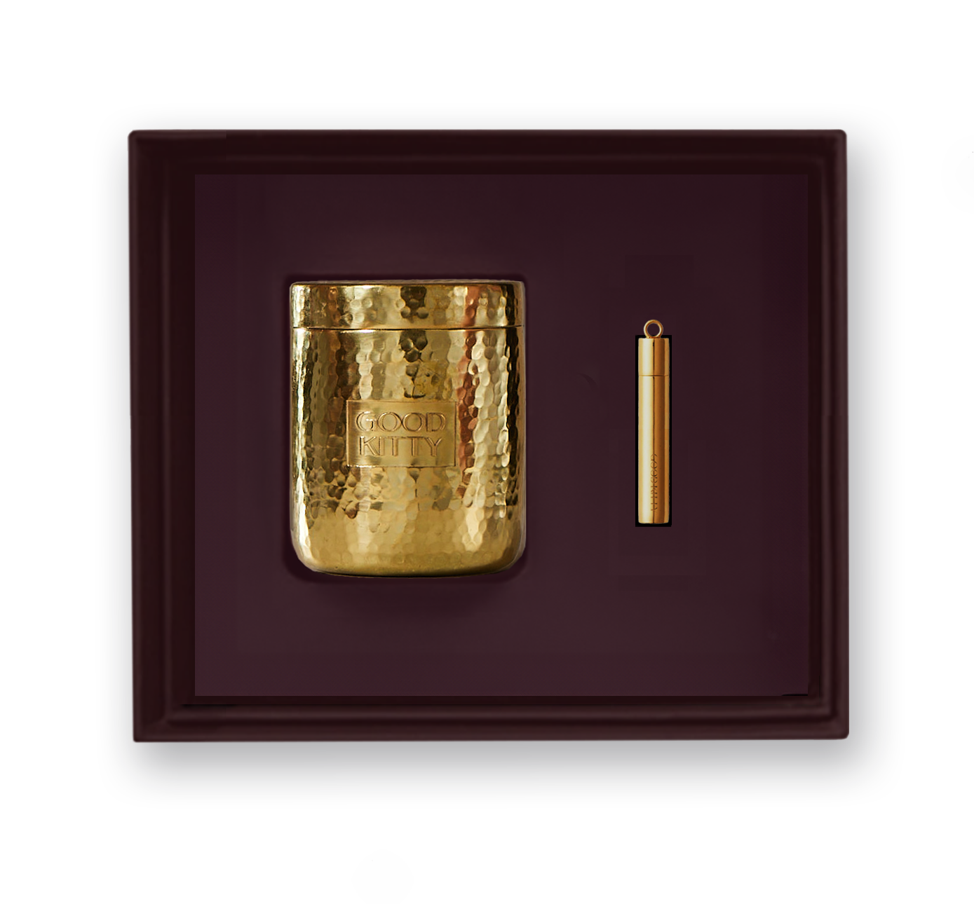 Luxury product presentation of Good Kitty's hammered gold pill container and matching gold pendant or pill holder, elegantly displayed against a deep burgundy velvet background in a gift box arrangement.