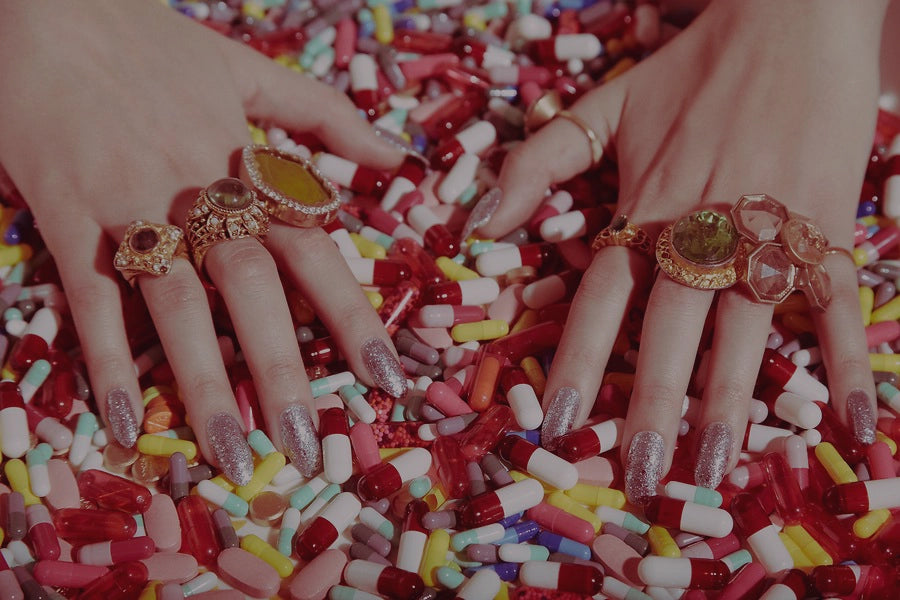Manicured hands with glittery nail polish holding colorful antibiotic pills with text overlay stating '70% OF BACTERIA IS DRUG RESISTANT' and 'are preventive antibiotics worth it?' The image explains the changing landscape of UTI prevention due to antibiotic resistance, with a 'learn more' button.