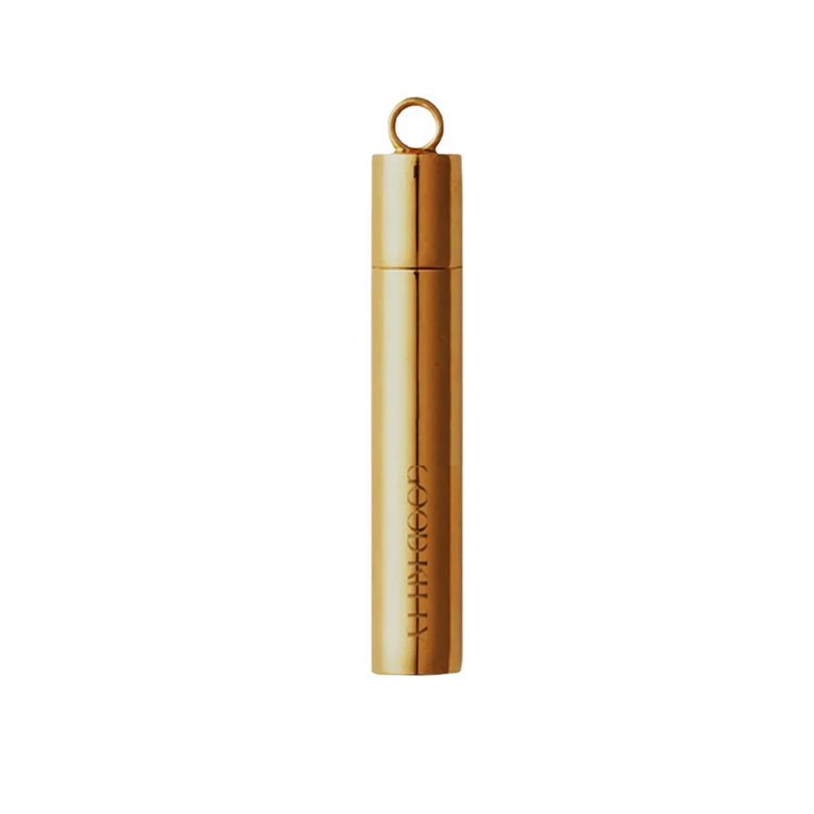 Gold cylindrical pill case pendant with ring attachment and embossed Good Kitty branding against a minimal beige background.