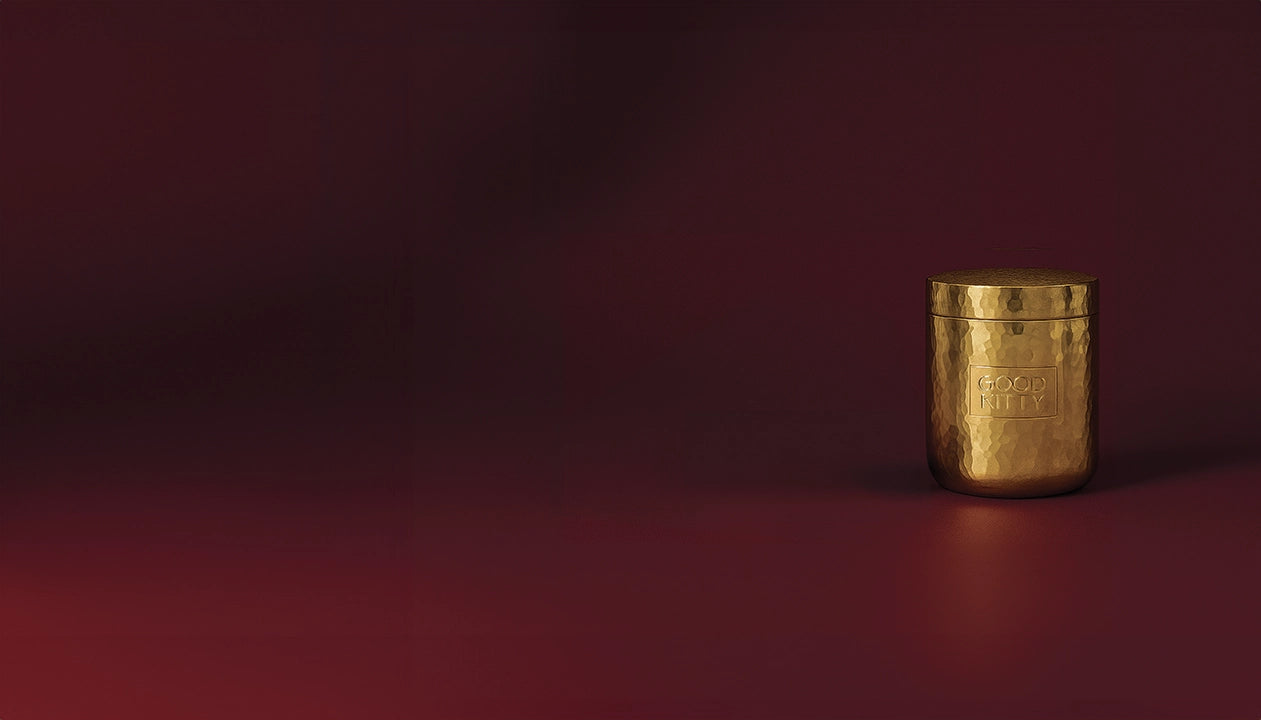 Gold cylindrical container on a dark red background
