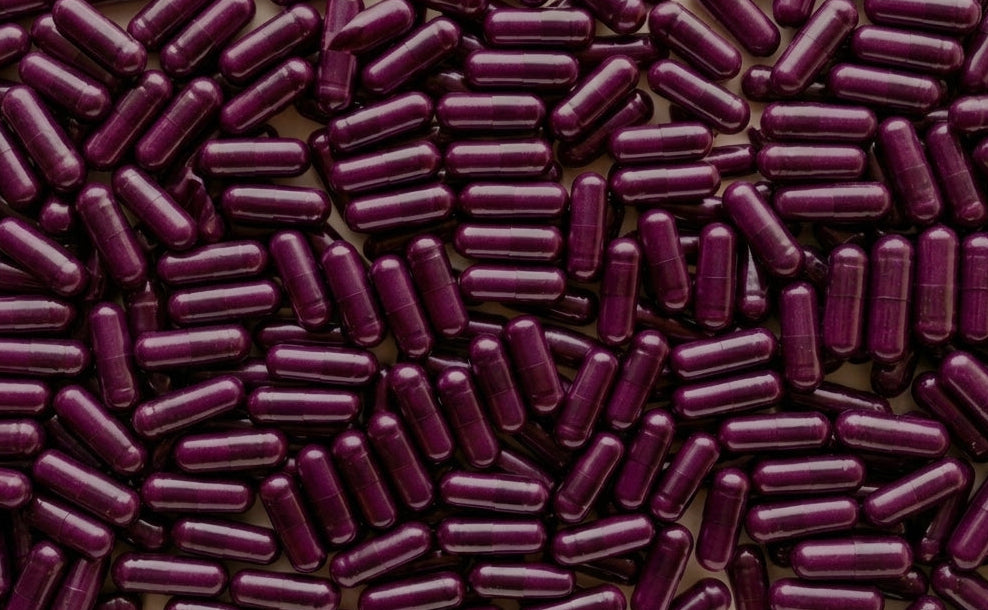 Close-up of purple cylindrical capsules on a white background Good Kitty Co
