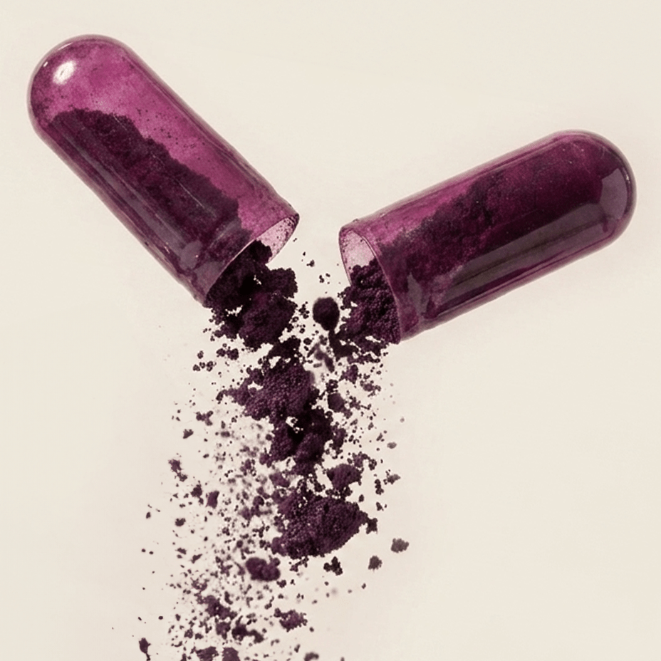 Purple capsules with powder spilling out on a beige background