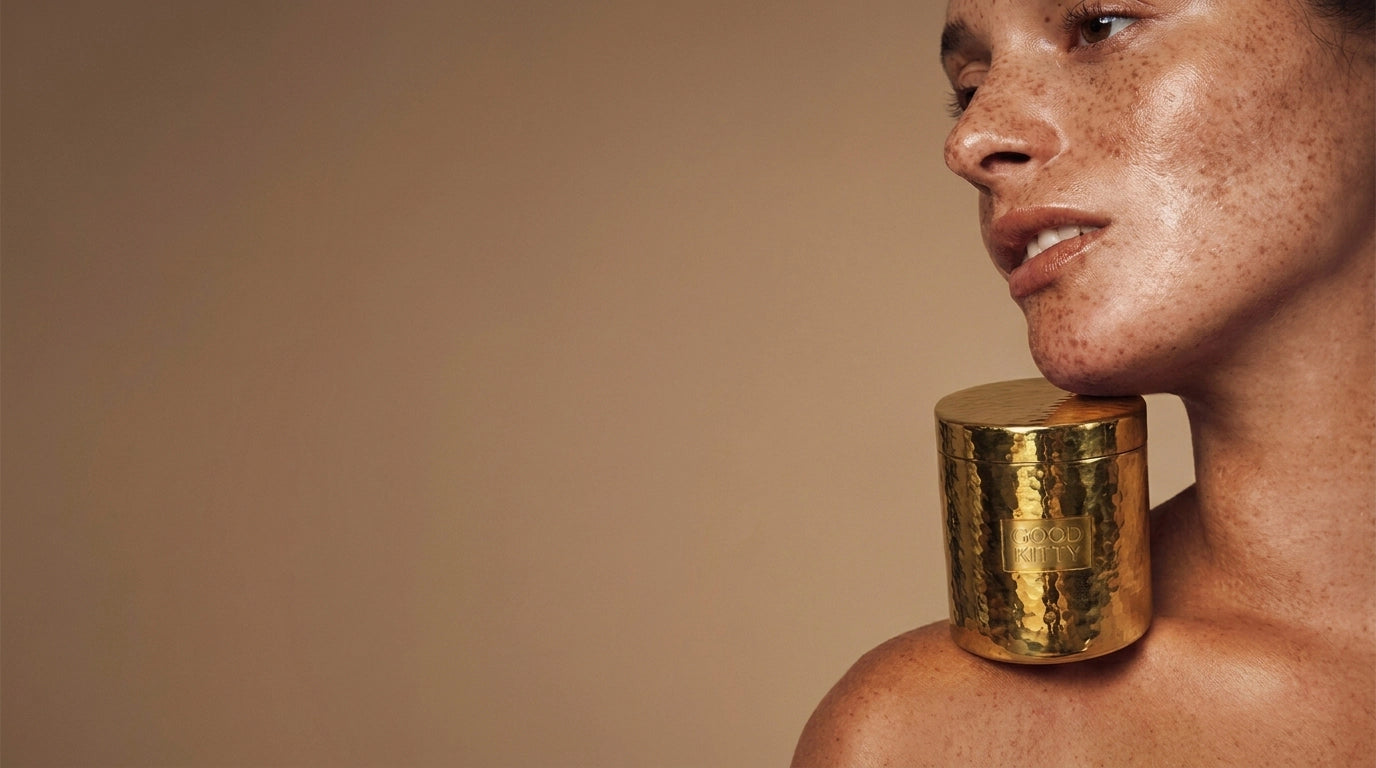 Woman holding Good Kitty Co UTI Biome Shield Gold Canister between her chin and shoulder