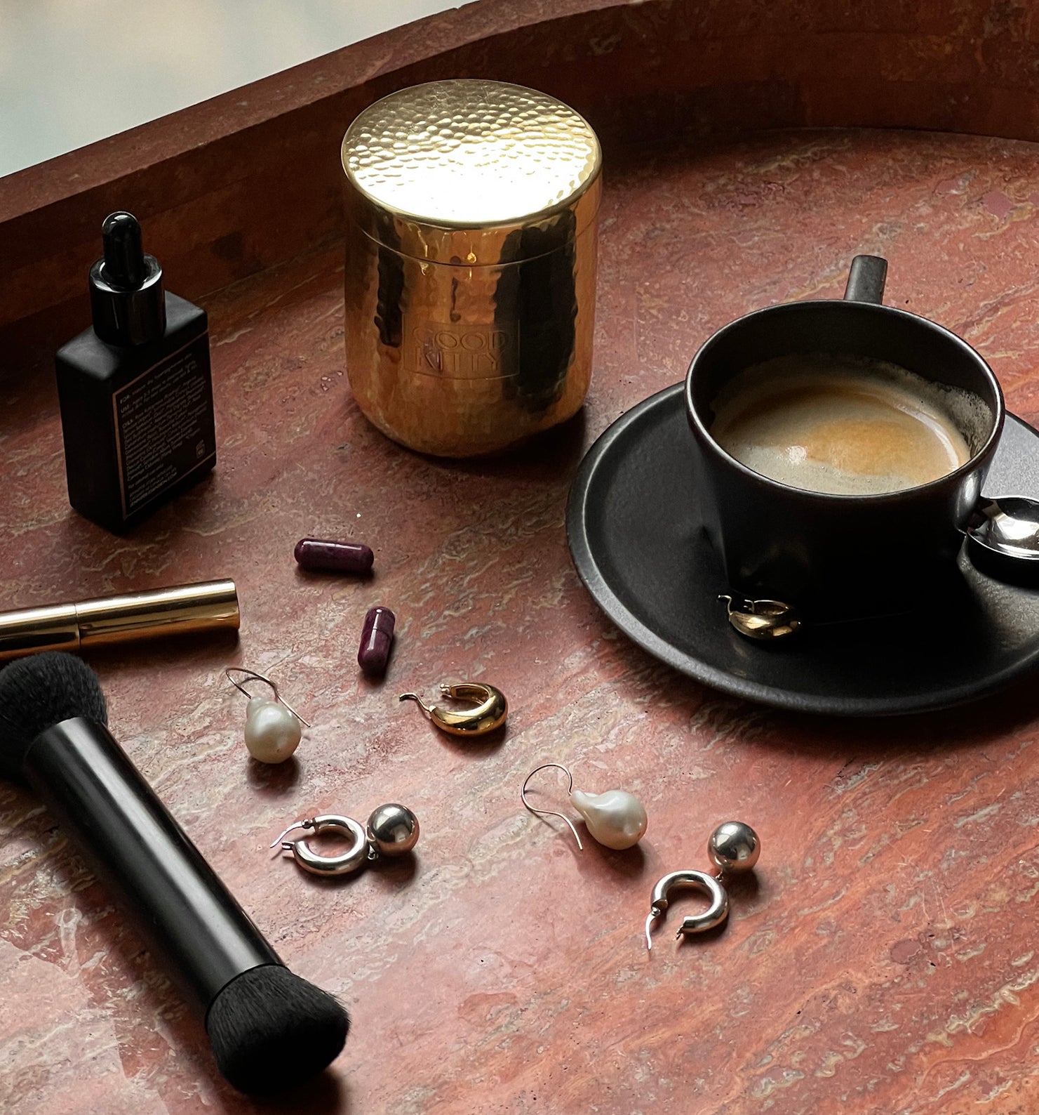 Jewelry on a table with a cup of coffee and other items