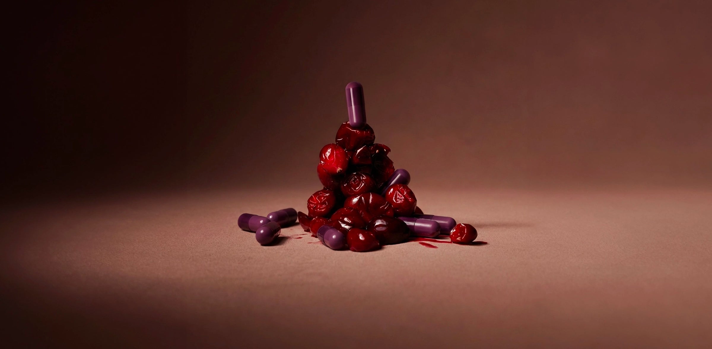 Cranberries stacked with purple capsules representing cranberry extract used for UTI prevention.